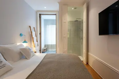 a bedroom with a bed with a television and a shower at Blau 1911 in Porto