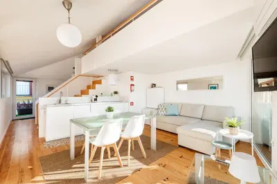 a kitchen and living room with a table and chairs at Casa Flora in Porto