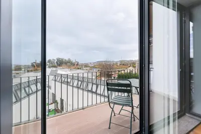 a chair sitting on a balcony with a view of a street at Sunshine Luxury House Urban Retreat Downtown Porto in Porto