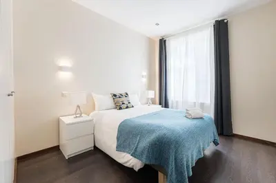 a bedroom with a bed with a blue blanket and a window at GuestReady - Enigma Apartments in Porto