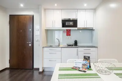 a kitchen with white cabinets and a table and a sink at GuestReady - Enigma Apartments in Porto