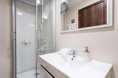 a white bathroom with a sink and a shower at GuestReady - Enigma Apartments in Porto