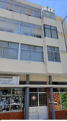 a large white building with a store front at Ap Centro de Gaia in Vila Nova de Gaia