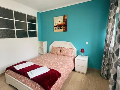 a bedroom with a bed and a blue wall at Ap Centro de Gaia in Vila Nova de Gaia