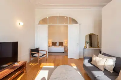 a bedroom with a bed with two lamps and a chair at Modern Charming Loft with balcony in central Porto by Lisbeyond in Porto