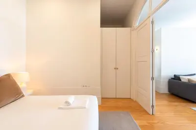 a dining room table with two chairs and a table with flowers at Modern Charming Loft with balcony in central Porto by Lisbeyond in Porto