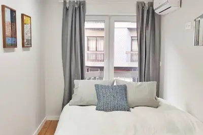 a bedroom with a white bed with a window at Two Bedroom Terrace Sanctuary in the Center in Porto