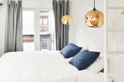 a white bed with blue pillows in a bedroom at Two Bedroom Terrace Sanctuary in the Center in Porto