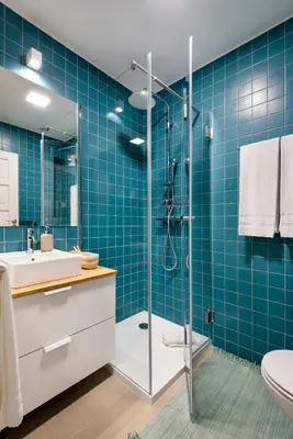 a bathroom with a sink and a shower with blue tiles at Trendy and Modern 3BR Family Home in Porto
