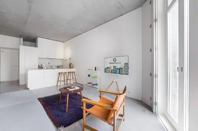 a kitchen with white cabinets and a table and chairs at GuestReady - The Modern Silveira in Porto