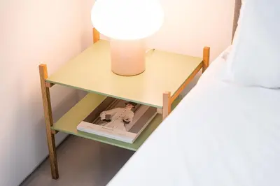 a bedside table with a lamp and a book at GuestReady - The Modern Silveira in Porto