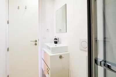 a white bathroom with a sink and a mirror at PortoDise Loft by RDC in Porto