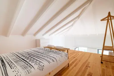 a bedroom with a bed and a wooden floor at PortoDise Loft by RDC in Porto