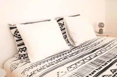 a bed with black and white pillows on it at PortoDise Loft by RDC in Porto