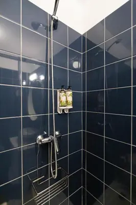 a shower in a bathroom with blue tiles at OPO Vale Formoso I in Porto