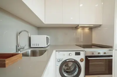 a kitchen with a washing machine and a sink at Modern & Stylish Apartments by Vacationy in Porto