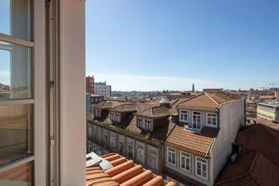 a view of the roofs of buildings from a window at ORM Portas Santa Catarina Apartments in Porto