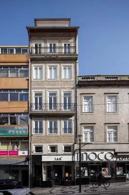 a tall building with a person riding a bike in front of it at ORM Portas Santa Catarina Apartments in Porto