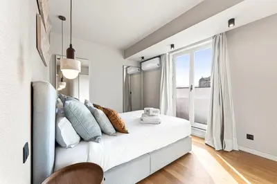 a bedroom with a white bed with pillows and a window at GuestReady - Blue shades with panoramic city views in Porto
