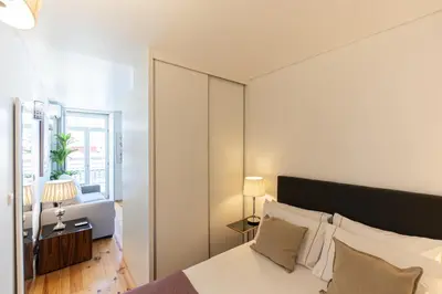 a bedroom with a bed and a large window at Lovely Bonfim in Porto