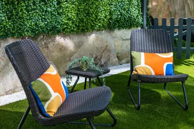 two chairs with pillows sitting on the grass at Pestana Apartments - Premium in Porto