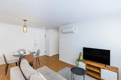a living room with a couch and a tv and a table at Pestana Apartments - In city center, Modern, New and Cozy in Porto