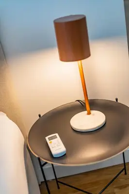 a table with a lamp and a remote control on it at Pestana Apartments - In city center, Modern, New and Cozy in Porto