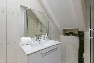 a white bathroom with a sink and a mirror at GuestReady - Miragaia Stone Studios & Apartments in Porto