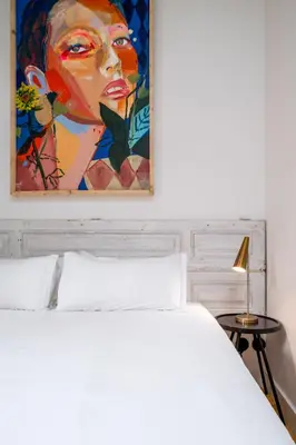 a bedroom with a bed and a painting of a woman at Limehome Porto Rua Das Oliveiras in Porto