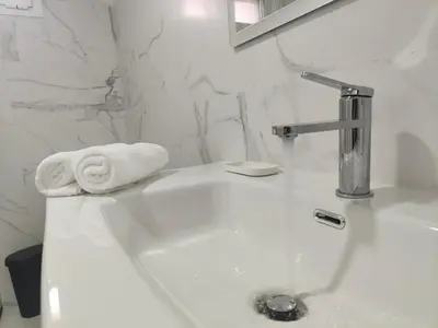 a white bathroom with a sink with a towel on it at Casa Mini-Ventuzelo by JC in Porto