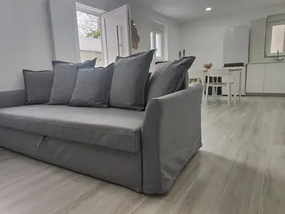 a gray couch sitting in a living room at Casa Mini-Ventuzelo by JC in Porto