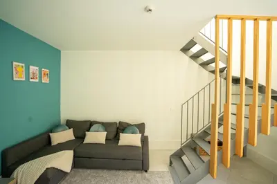 a living room with a couch and a staircase at Ilha Douro Duplex in Porto