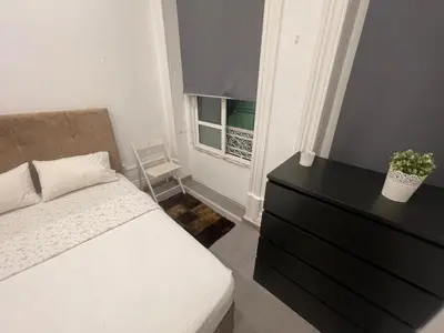 a bedroom with a bed and a dresser and a window at Guesthouse Franco in Porto