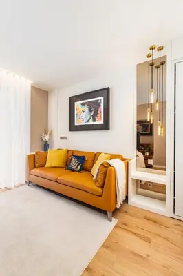 an orange couch in a living room with a mirror at Design Flat in Porto Downtown II in Porto