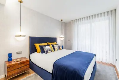 a bedroom with a large bed with blue and yellow pillows at Design Flat in Porto Downtown II in Porto