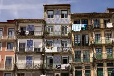 a table with two chairs and a window with a view at Alma das Taipas Apartment in Porto