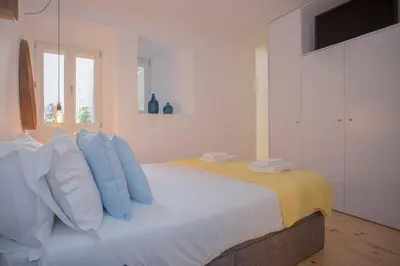a bedroom with a bed with blue and white pillows at Liiiving in Porto - Clérigos Terrace Apartment in Porto
