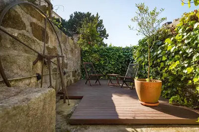 a wooden deck with a potted plant on it at MARKES · Lovely 1-bedroom home w/ sunny backyard in Porto