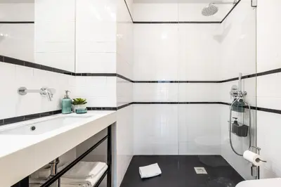a white bathroom with a sink and a shower at Aliados luxurious home in Porto