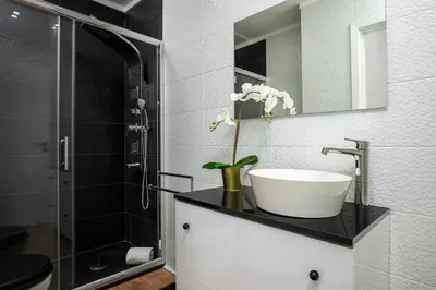 a bathroom with a sink and a glass shower at Lovely 2BR w/ views over the river, parking incl in Vila Nova de Gaia