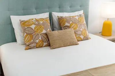 a white bed with four pillows and a yellow lamp at Lovely 2BR w/ views over the river, parking incl in Vila Nova de Gaia