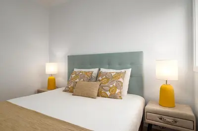 a bedroom with a bed with two lamps on it at Lovely 2BR w/ views over the river, parking incl in Vila Nova de Gaia