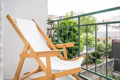 a wooden rocking chair sitting on a balcony at Panorama Apartments Porto Clerigos in Porto