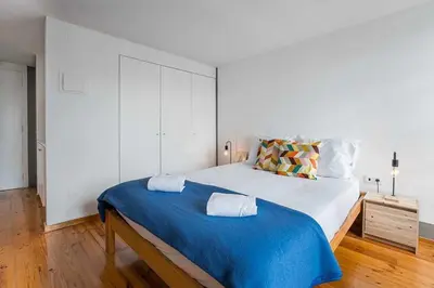 a bedroom with a large bed with a blue blanket at Panorama Apartments Porto Clerigos in Porto