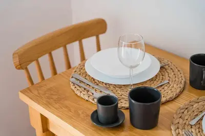 a wooden table with a plate and a wine glass at Panorama Apartments Porto Clerigos in Porto