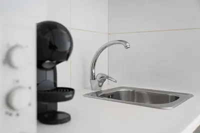 a kitchen with a sink and a black coffee maker at Panorama Apartments Porto Clerigos in Porto