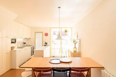 a kitchen and dining room with a wooden table and chairs at Casa 128 by LovelyStay in Porto