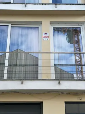 a balcony of a building with a crane in a window at We are tourist in Vila Nova de Gaia
