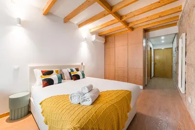 a bedroom with a large bed with towels on it at GuestReady - Miragaia Stone Studios & Apartments in Porto