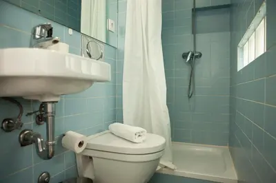 a blue tiled bathroom with a toilet and a sink at PORTO CONCEPT HOME - Campo Alegre in Porto